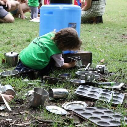 child playing with mud kitchen items