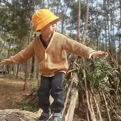 child climbing log at bush kindy